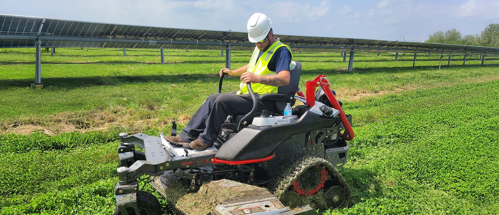 Reinhart employee on a ride-on mower in a solar farm